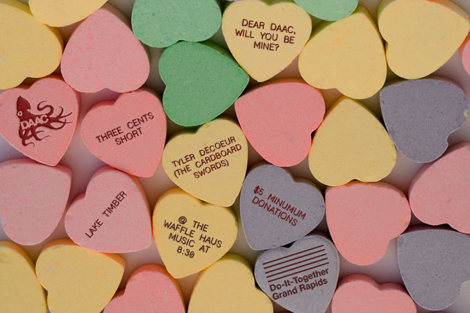 Candy conversation hearts with concert details printed on the backs
