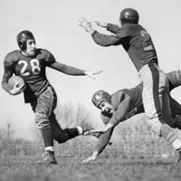 Photo of three men playing football wearing 50's uniforms