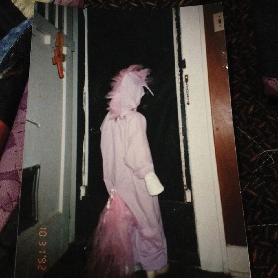 Shadowy photograph of a person in a pink unicorn suit