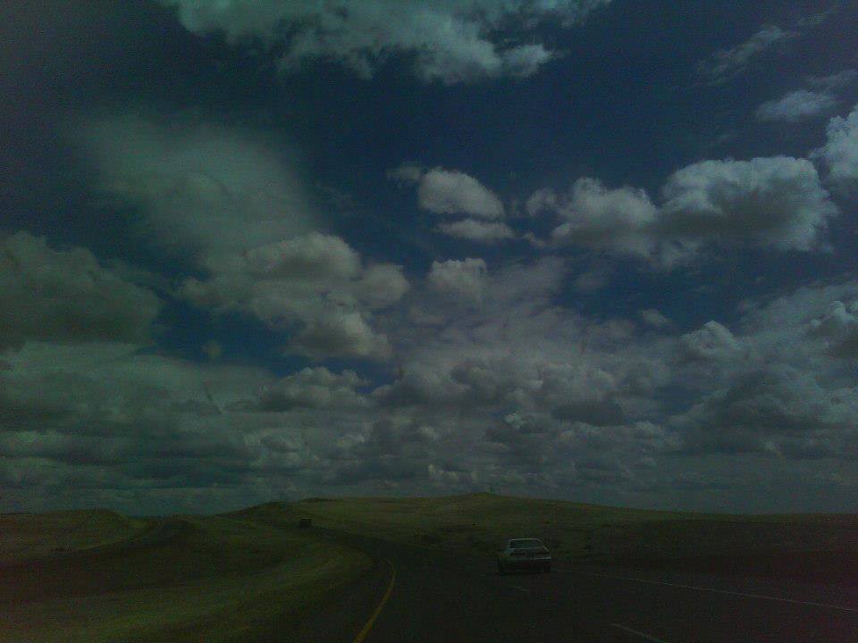 Dark photograph of a car driving on an open road