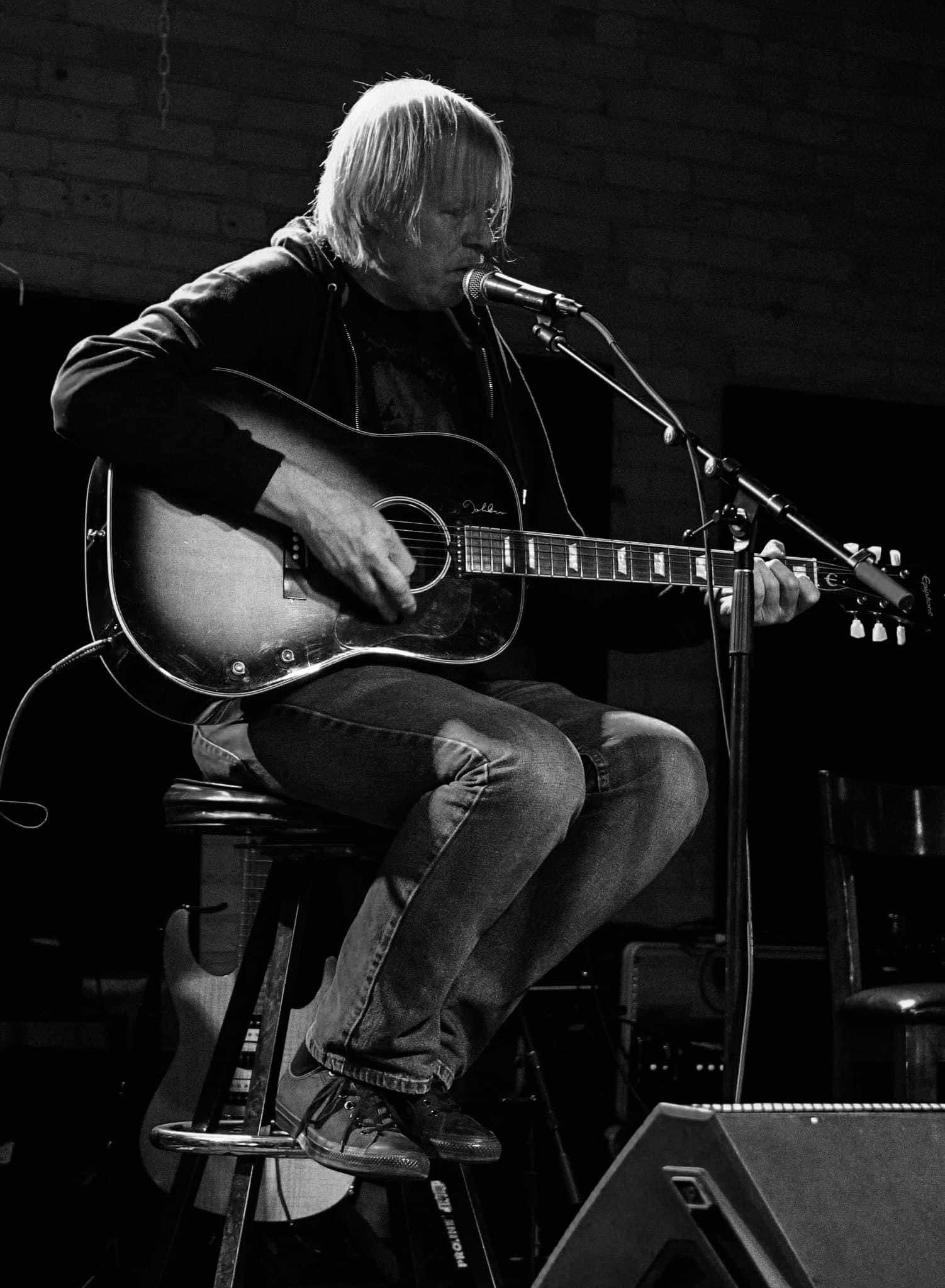 A solo guitarist sings at The DAAC open mic