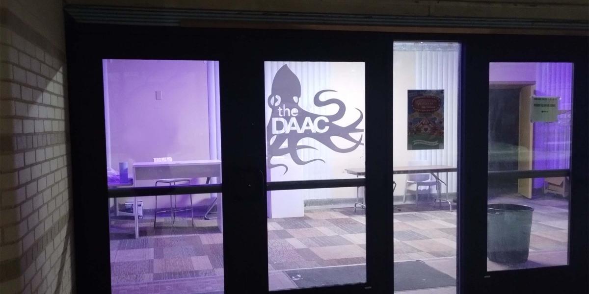 Exterior door of a building with daac octopus logo in window 