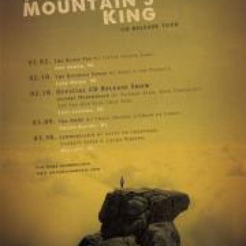 Lone figure atop a mountain, with tour dates