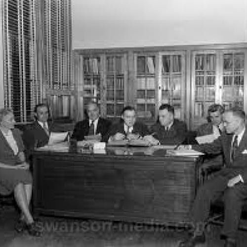 Seven people gathered around a desk